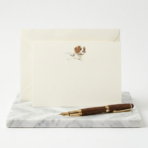 Correspondence card with dog illustration and fountain pen on marble surface