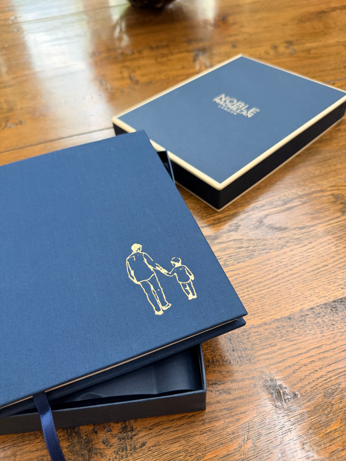 Noble Macmillan packaging with a close up of the gold foil engraving illustration